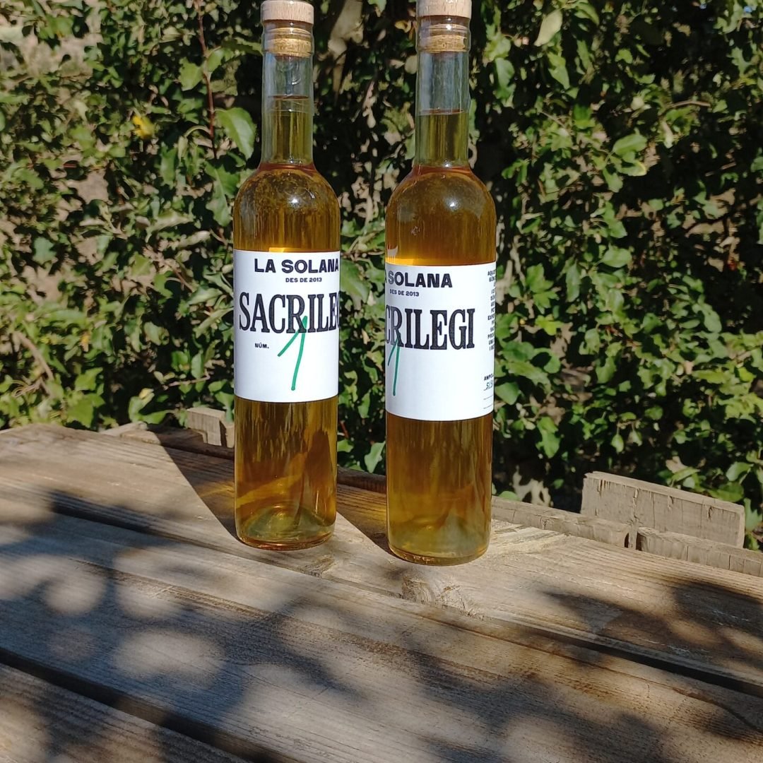 botellines de sidra sacrilegi la solana al sol en una mesa de madera